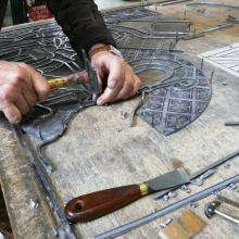 Pose et arrêt des profilés de plomb enchâssant chacune des pièces de verre